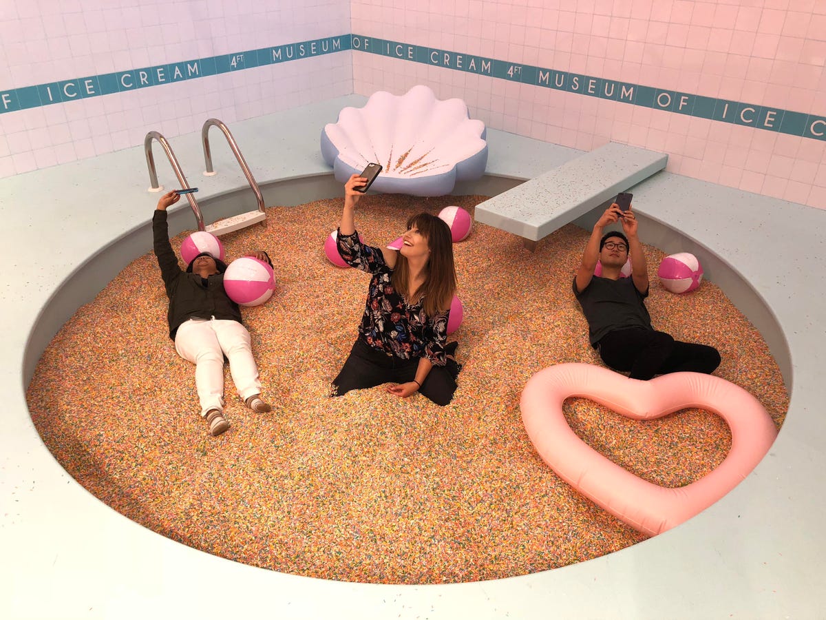 Mariel, Lexy and John take sefies in the Sprinkle Pool at the Museum of Ice Cream in San Francisco.