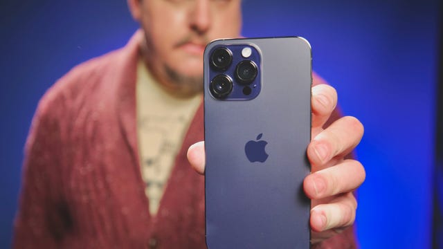A smart man holding an iPhone 14 Pro Max