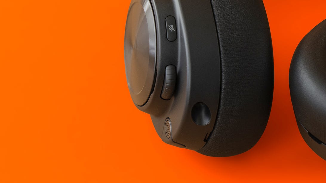 Closeup of the left earcup of the SteelSeries Arctis Nova Pro Wireless headset showing the completely retracted mic, volume dial and mute button