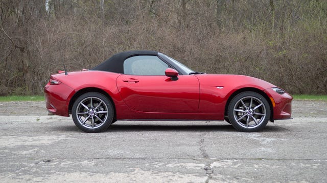 2022 Mazda MX-5 Miata in red, from the passenger side with the roof up