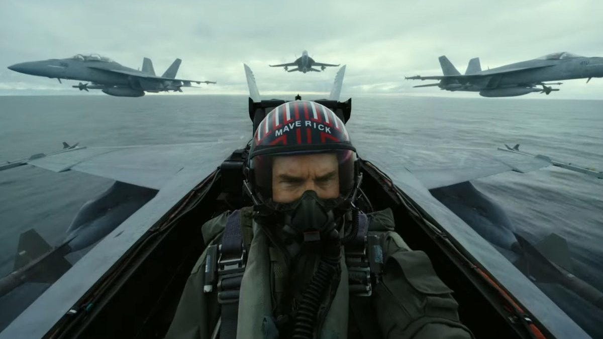 Cockpit view of Tom Cruise's fighter pilot Maverick, flanked by three other jets flying eye-wateringly close.