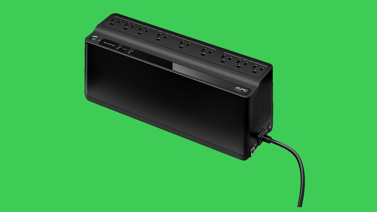An APC battery backup and surge protector against a green background.
