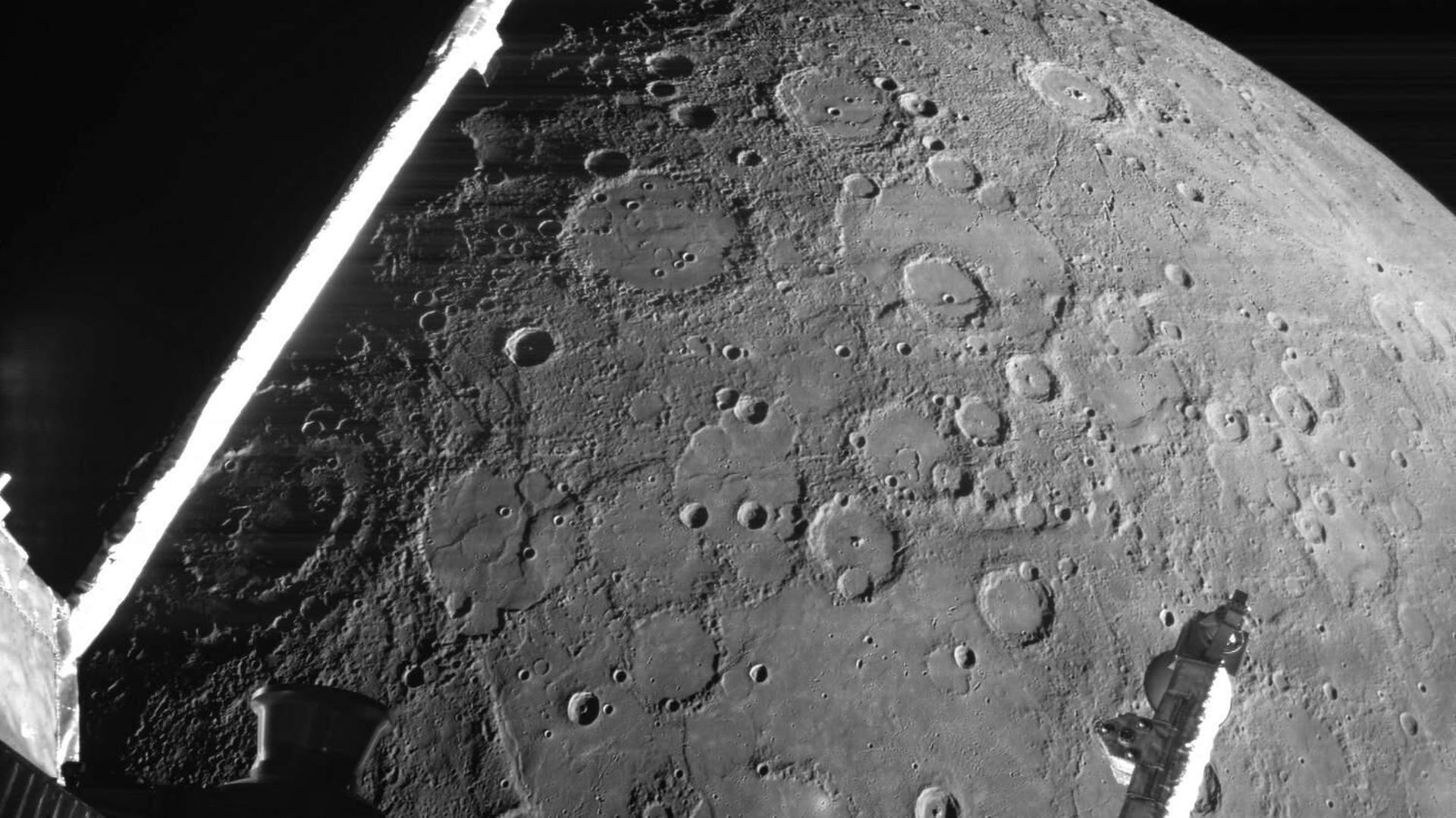 A black-and-white image of Mercury shows many craters and parts for the BepiColombo spacecraft.