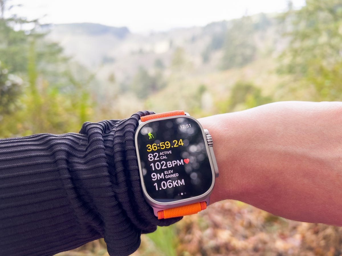 Apple Watch Ultra on a hike with hillside and trees