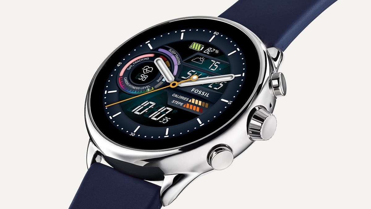 The Fossil smartwatch is centered in a silver case with a modest crown flanked by two buttons, with blue straps.