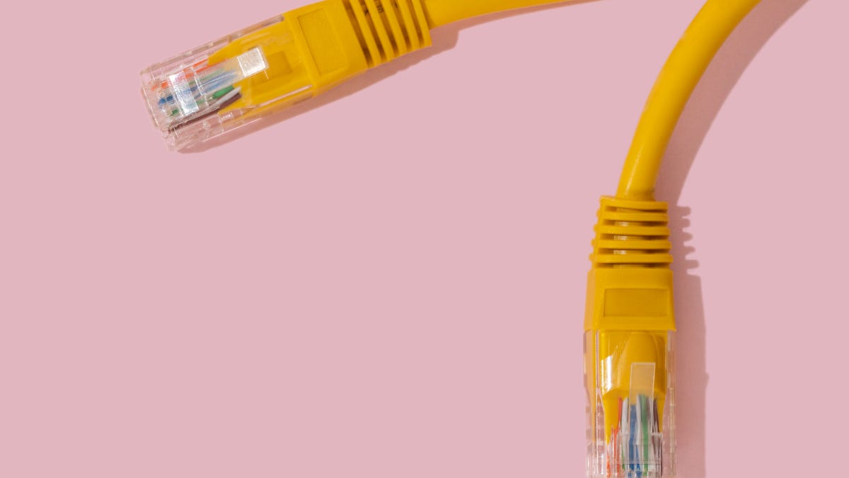 Yellow RJ54 ethernet connector on pink background.