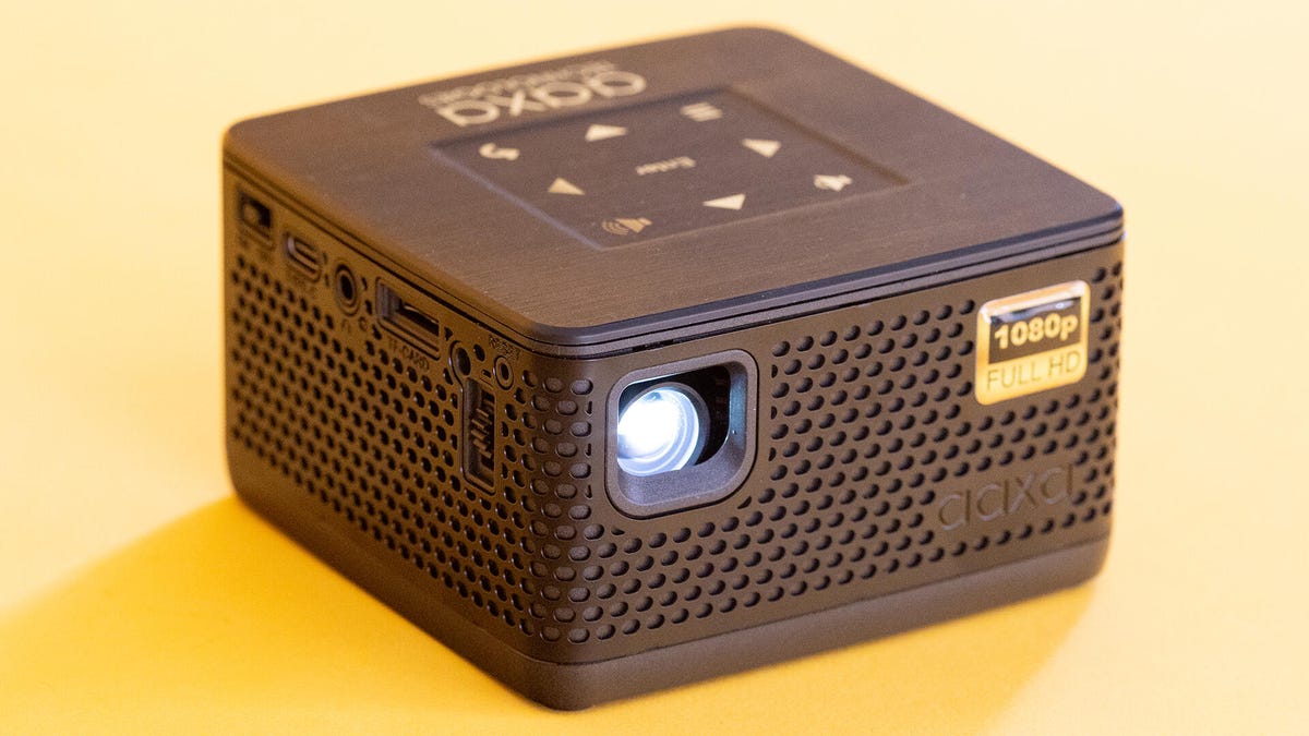 An angled view of the AAXA P7+ pico projector on a yellow background.