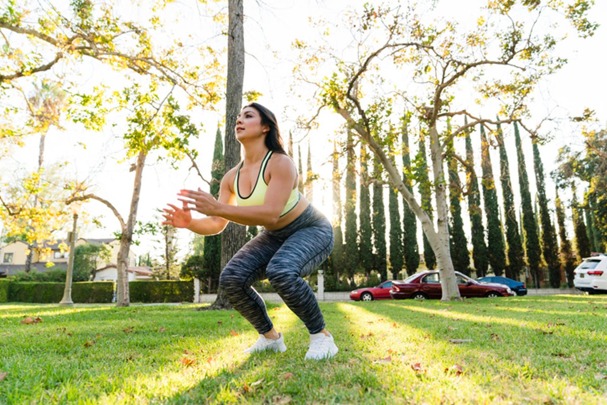 Woman practicing jumping squats in park