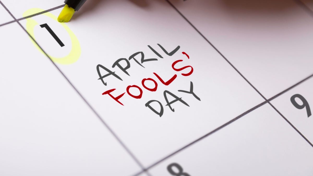 Close-up of a calendar, showing "April Fools&apos; Day" written in the square that denotes April first. Someone is circling the date using a neon yellow highlighter pen.