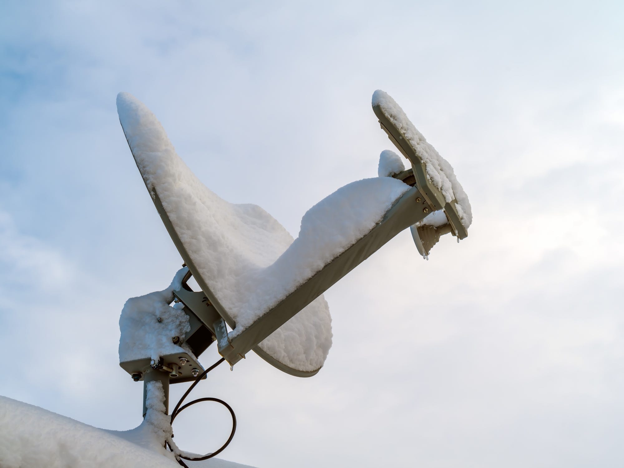 Rooftop satellite dish covered with snow