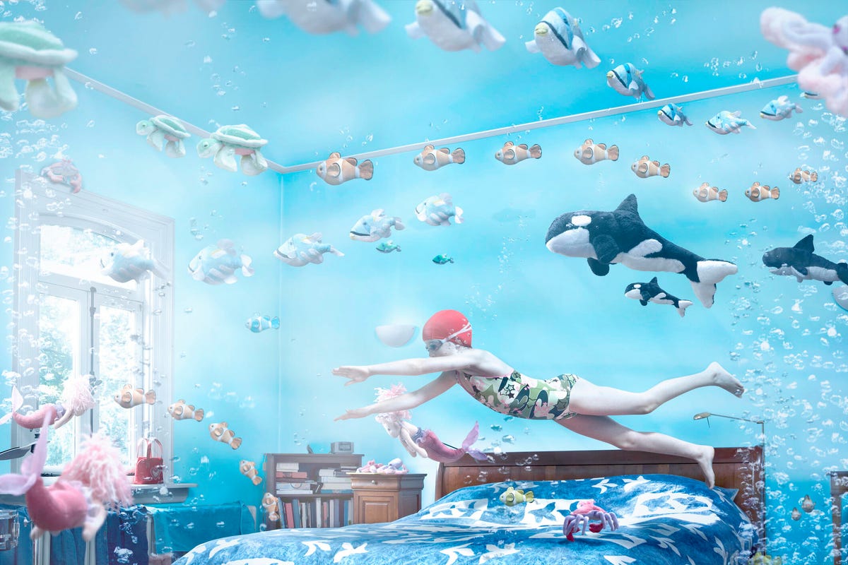 child swimming through a bedroom filled with water and fish
