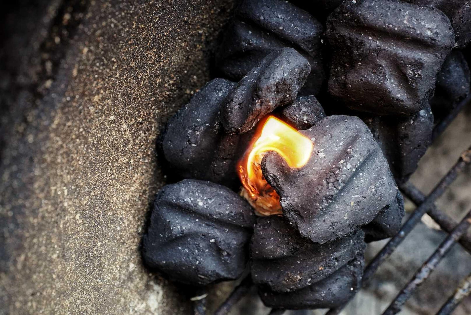Close-up of the charcoal briquette snake lit at one end 