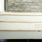 The Saatva Classic mattress inside of a bedroom and on top of an adjustable bed frame