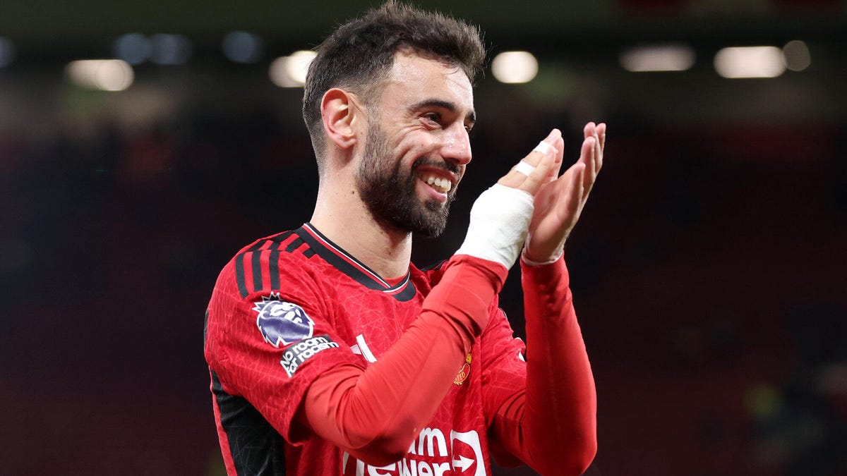 Bruno Fernandes of Manchester United, smiling, applauding, with right hand bandaged.