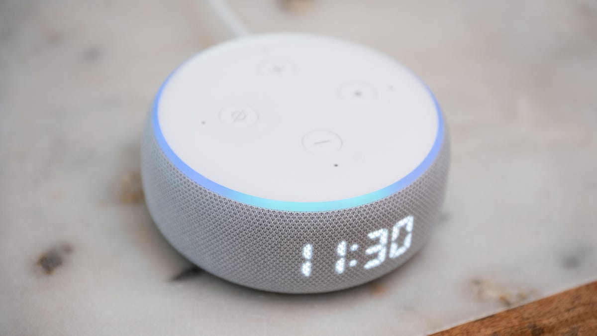 A white Amazon Echo Dot with clock 