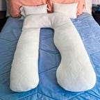 Newton Baby Pregnancy Pillow on a bed