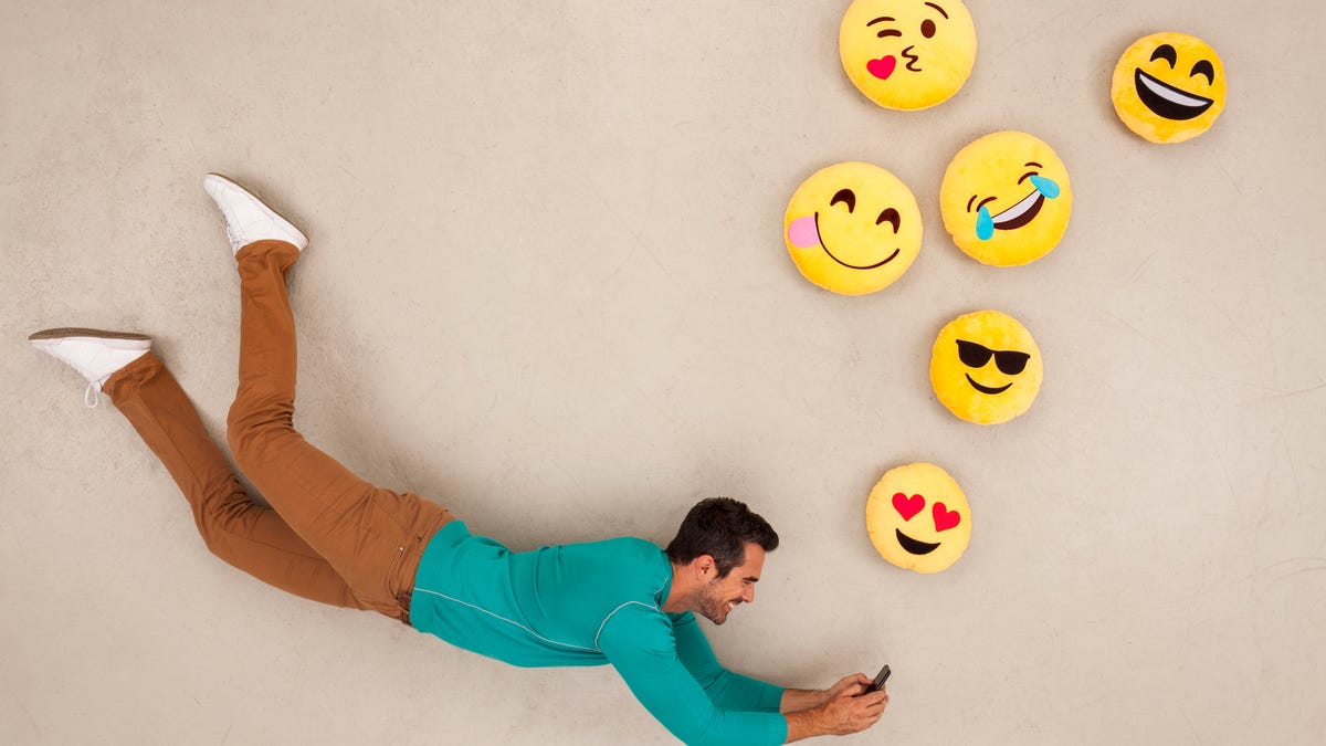 Man chatting on his smart phone, sending emojies