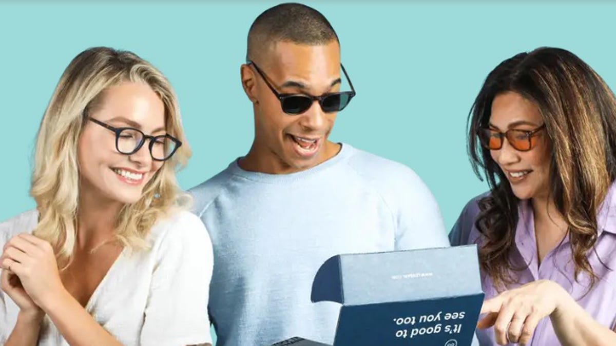 Three people wearing glasses or sunglasses look at a boxed shipment from Lensabl.