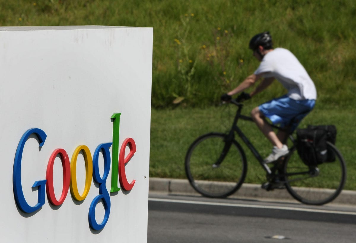 Cyclist rides past Google sign