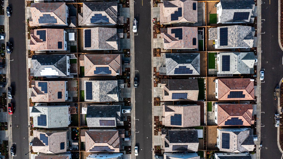 Aerial view of solar panels on roofs in a neighborhood.