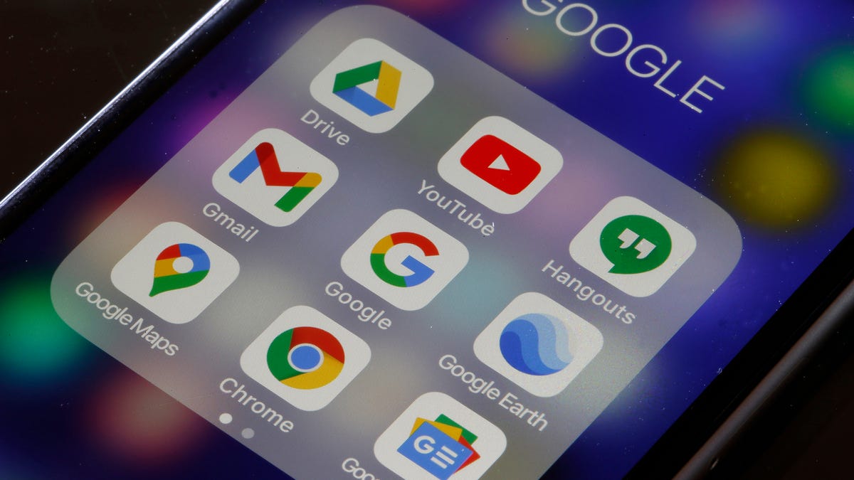 a photo of a smartphone screen showing Google apps like Drive, Gmail, YouTube and Hangouts