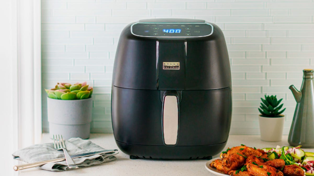 The Bella Pro 4-quart air fryer sits on a counter next to hot wings.