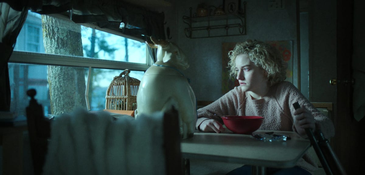 Ruth Langmore sitting with a goat cookie jar.