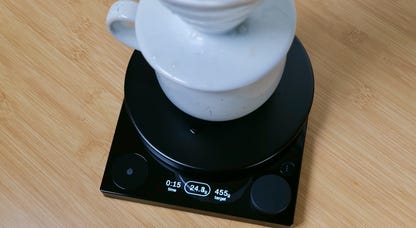 The Fellow Tally Pro coffee scale with a cup and a Hario V60 coffee brewer on top