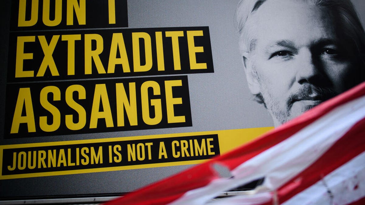 Sign with a photo of Julian Assange and a message reading "Don't extradite Assange. Journalism is not a crime."