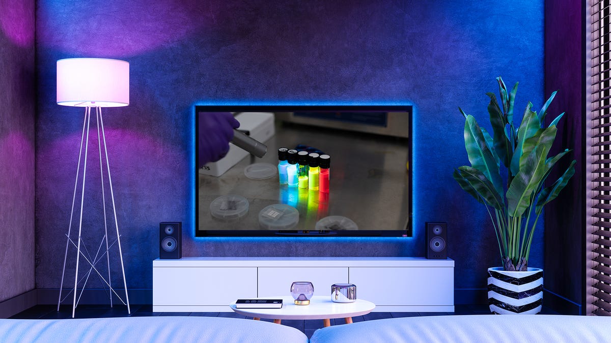 A purple and blue living room with a TV showing some quantum dots.