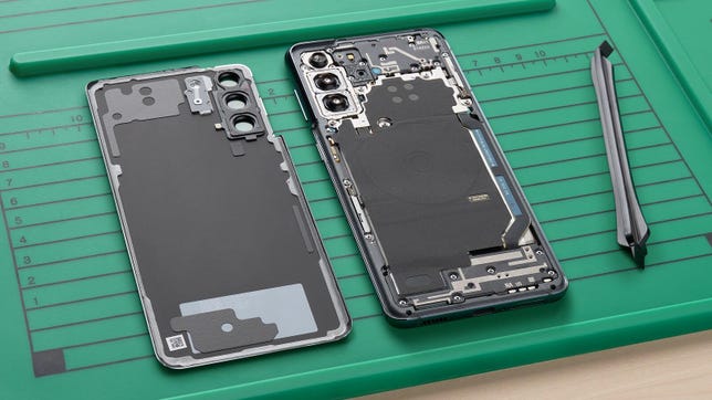 Ein Samsung S21-Telefon öffnete sich auf einer grünen Matte mit einem speziellen Reparaturwerkzeug.