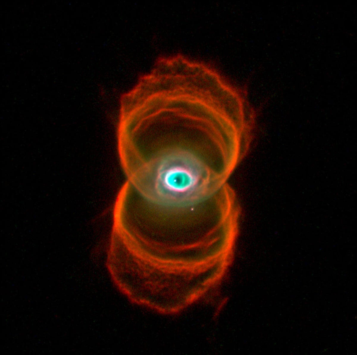 Overlapping reddish rings meet in the middle with an eye-like space formation in a nebula.