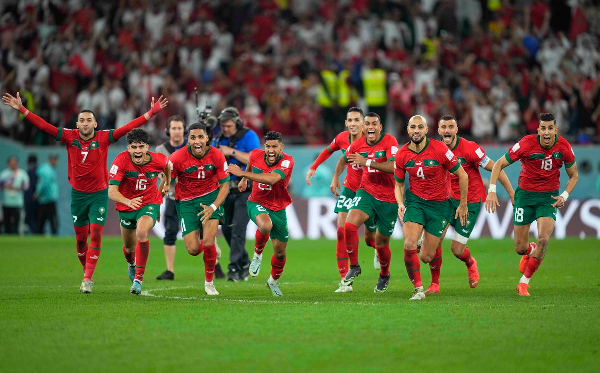The entire Morocco team running on the field after winning in a game against Spain in the 2022 World Cup.