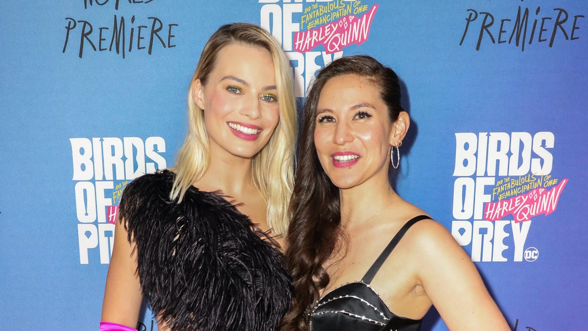 Margot Robbie and Christina Hodson stand together smiling. 