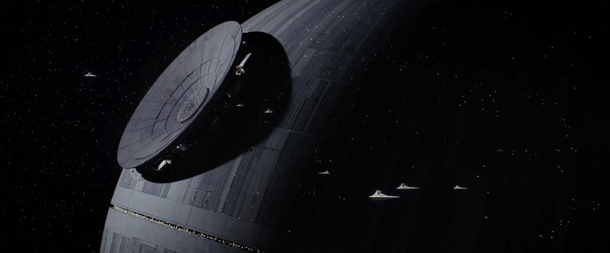 A portion of the Death Star with tiny Imperial cruisers flying by