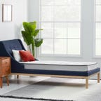 Wayfair mattress on a box spring in a bedroom with big windows