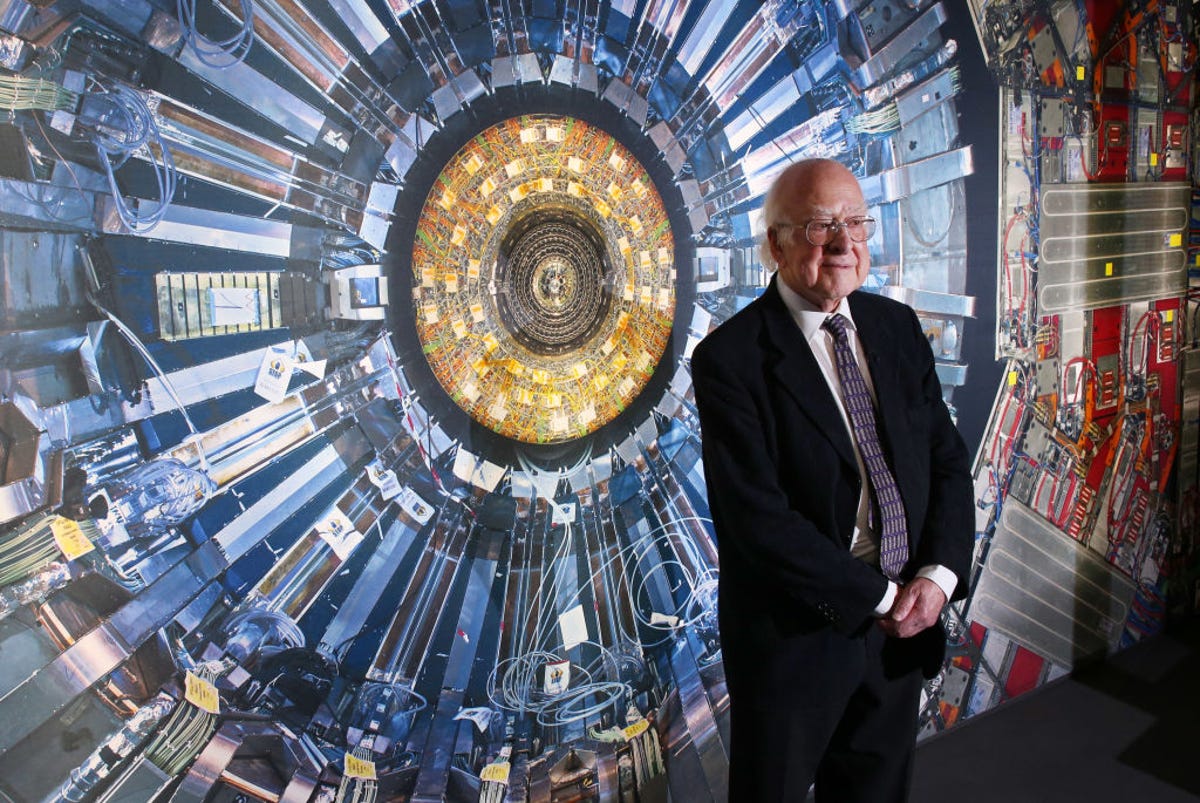 Peter Higgs in front of a photograph of the Large Hadron Collider