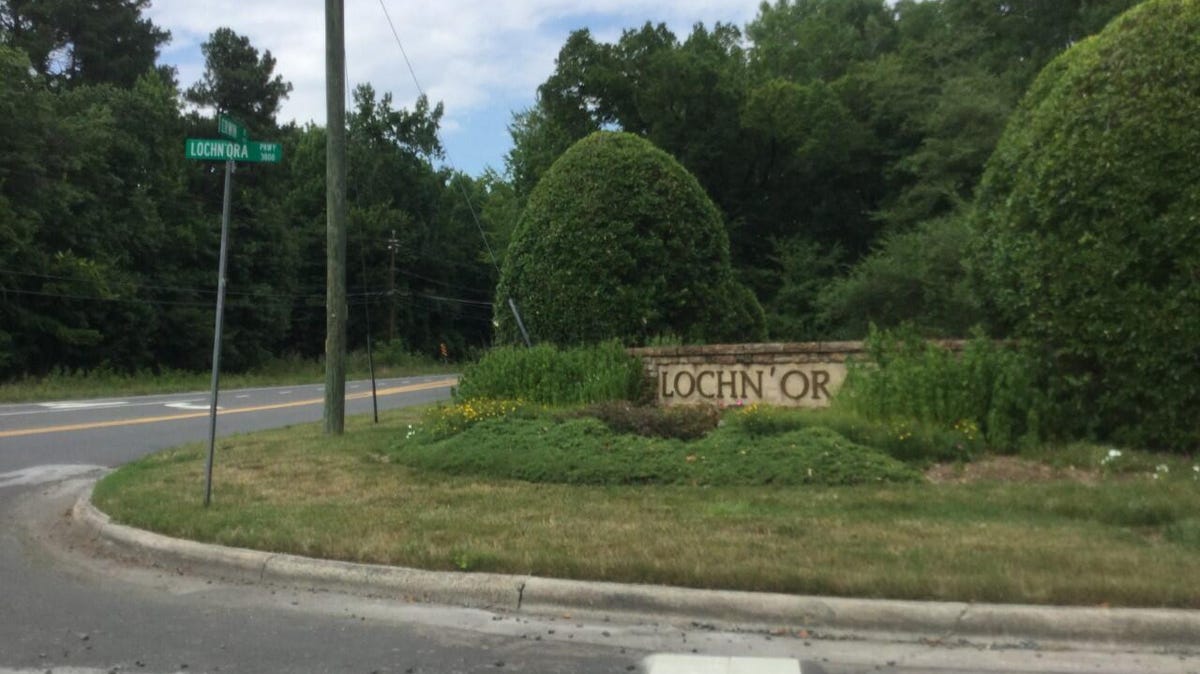 A stone sign for the Lochn'ora neighborhood, surrounded by shrubs