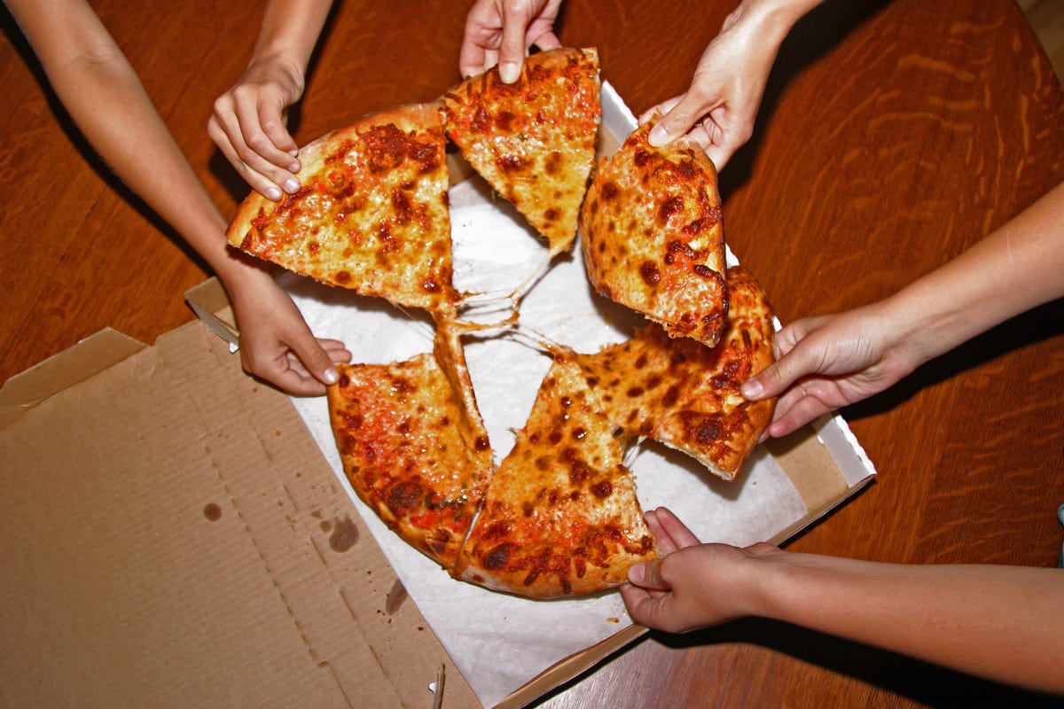 Hands grabbing slices of pizza