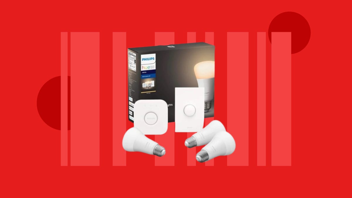 The Philips Hue Starter Kit with three smart bulbs, a smart button and a hub is displayed against a red background.