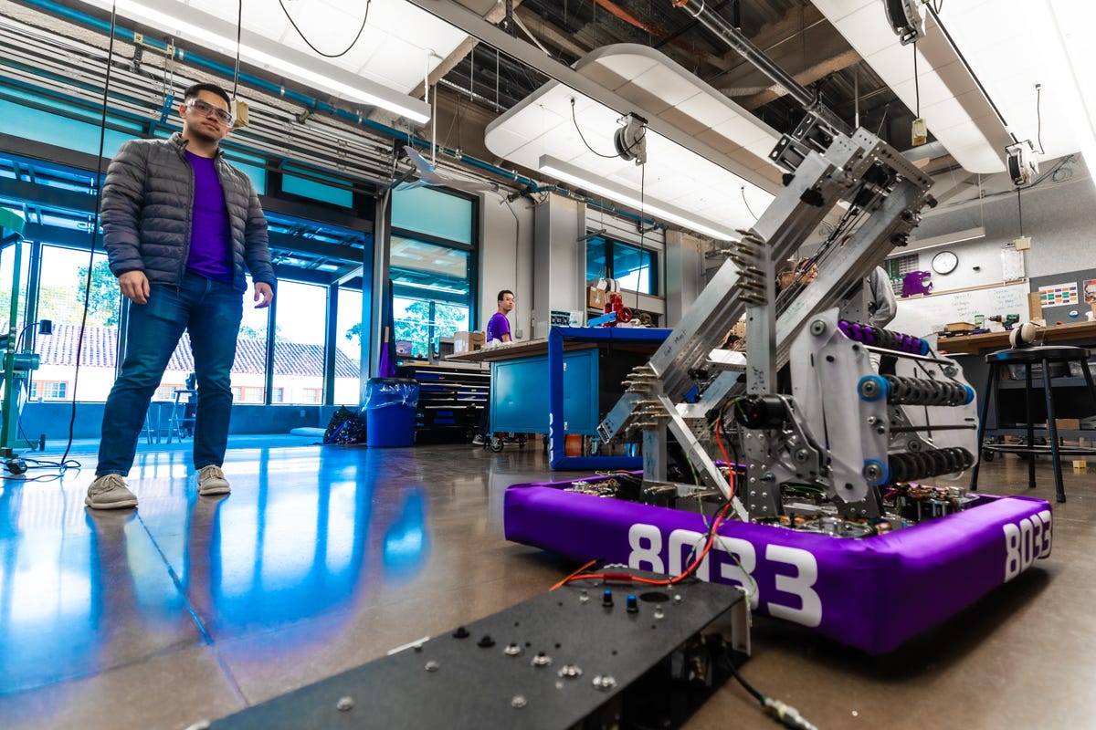 Mentor Michael Abbott stands with the evolving robot in the teams lab in Piedmont, California.
