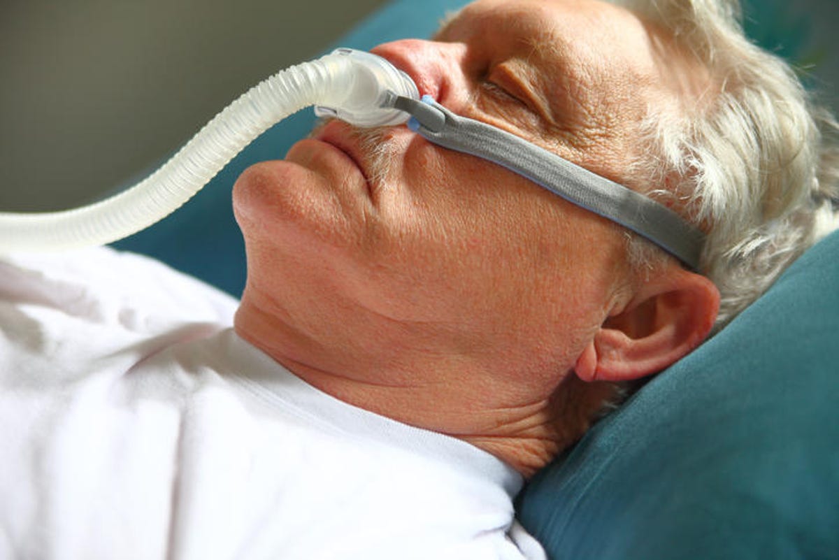 Close-Up Of Senior Patient With Pipe Attached To Nose Lying On Hospital Bed