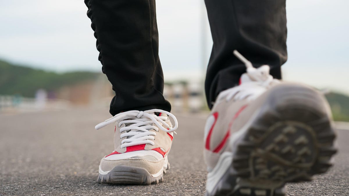 Close-up on a person's feet in walking shoes on pavement