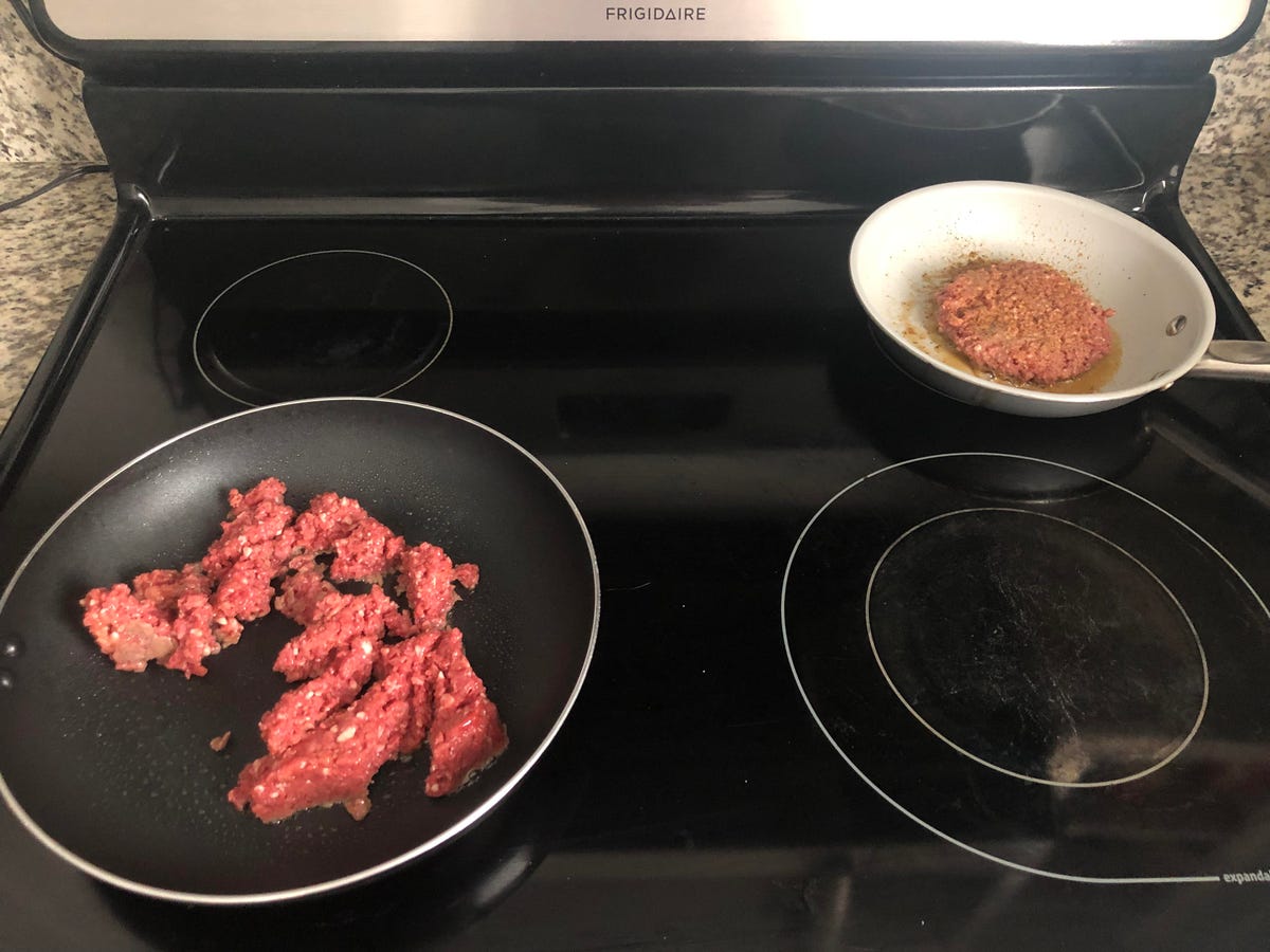 A stovetop with an Impossible Burger patty and some beef cooking