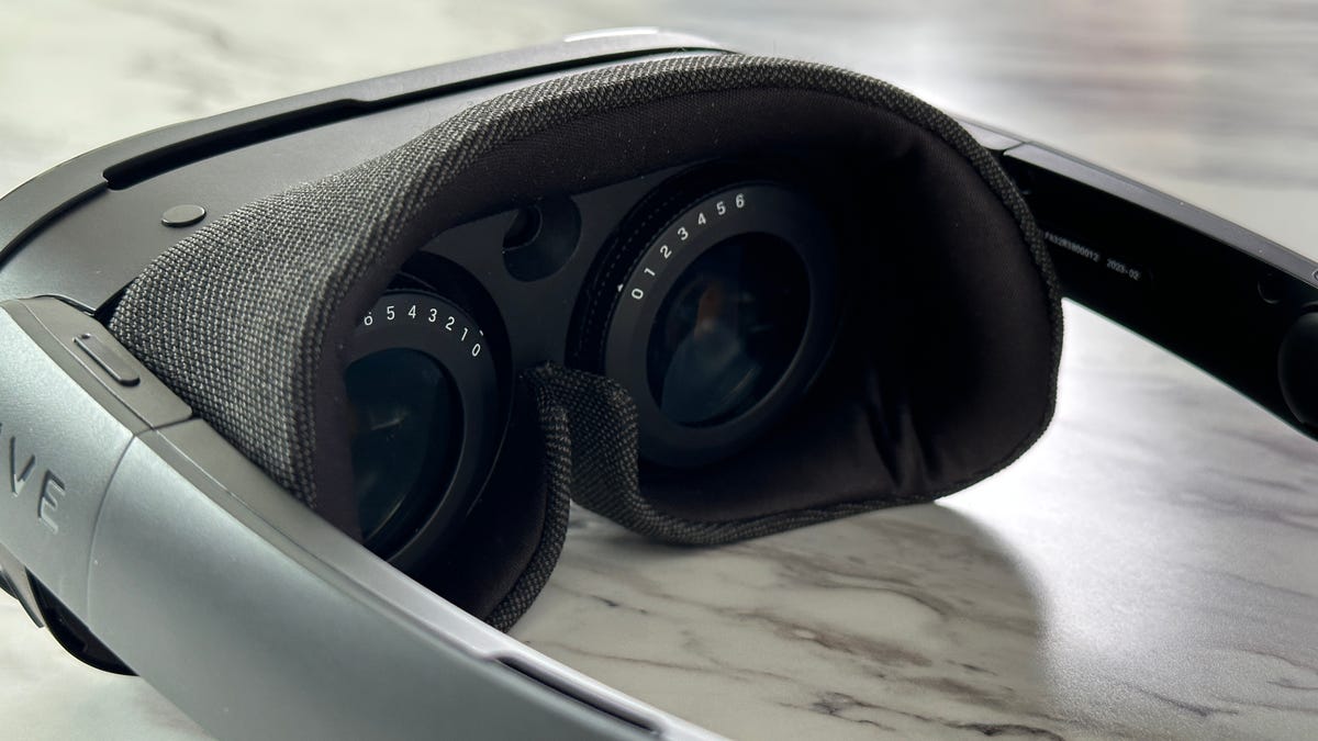 As lentes de um headset Vive VR, com um anel de números no mostrador mostrando as configurações de prescrição.