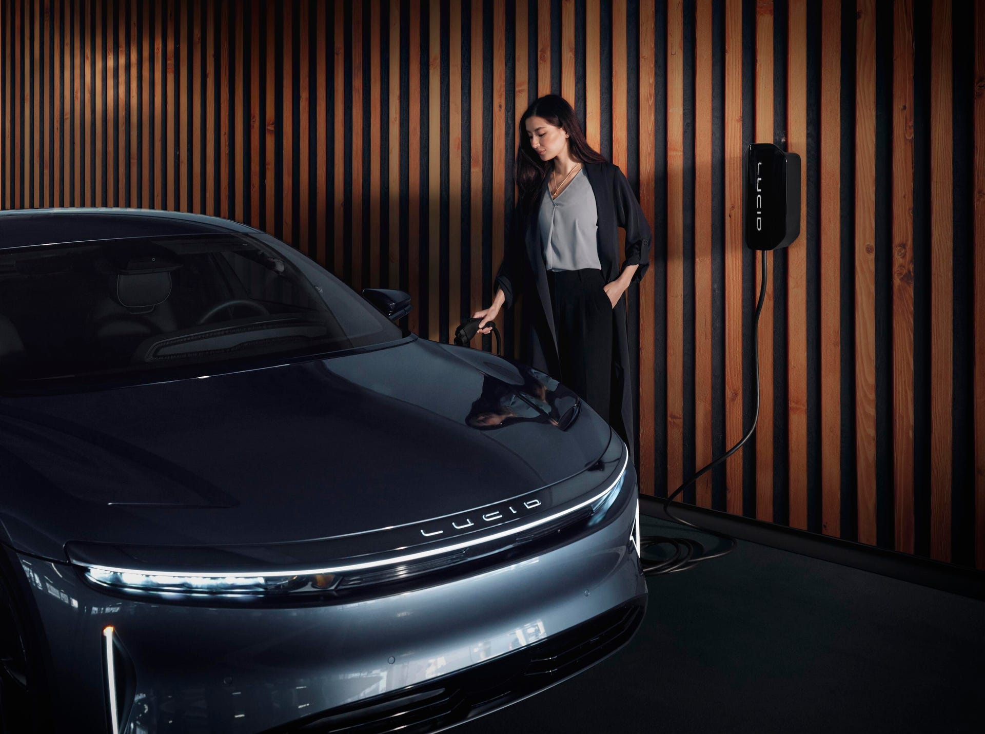 Person plugs in a Lucid Air sedan at a Lucid home charging station