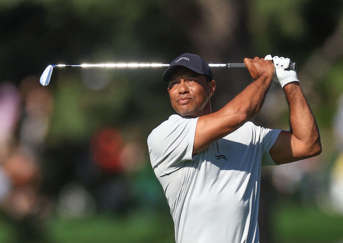 Tiger Woods holds his follow-through as he watches the flight of the ball