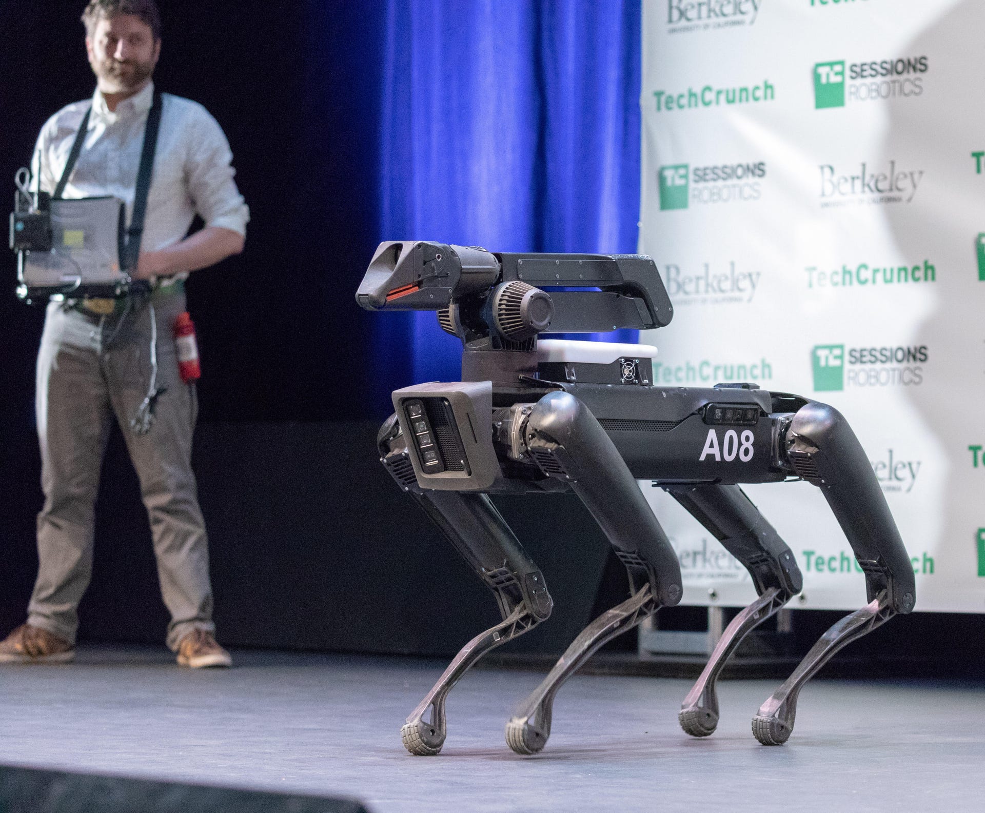 A human operator pilots a Boston Dynamics SpotMini quadrupedal robot, giving commands about where to go but not how exactly to position its legs.