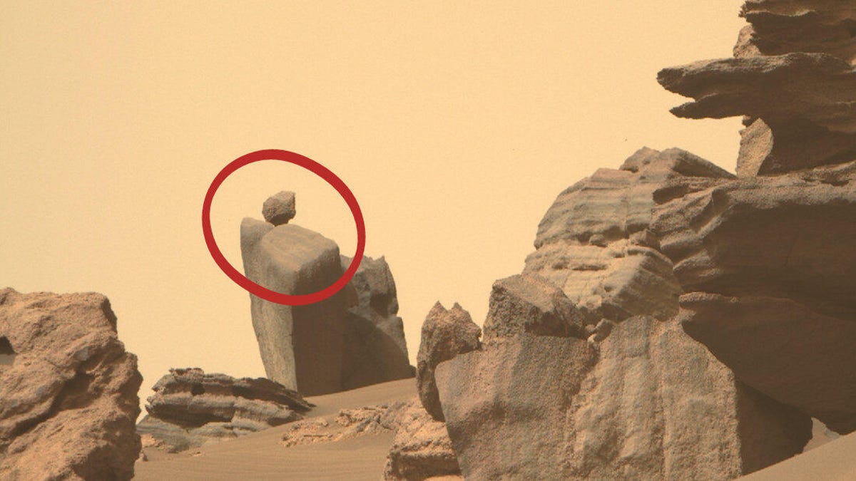 A cropped look at a Mars landscape has a red circle highlighting a small round rock balanced on a larger angular rock.