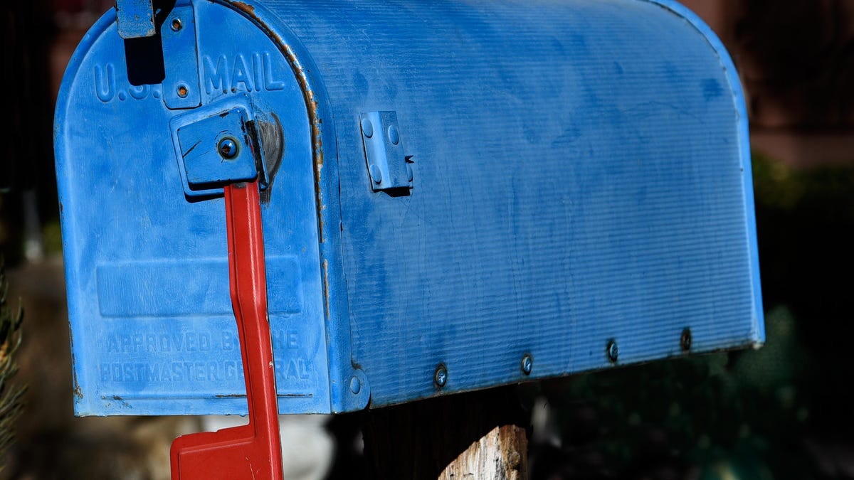 A blue mailbox with a red flag pointed down.
